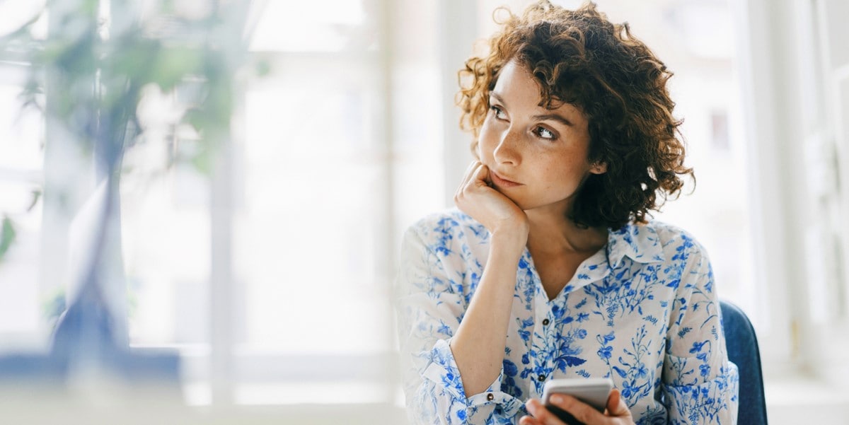 woman at desk resting chin on hand