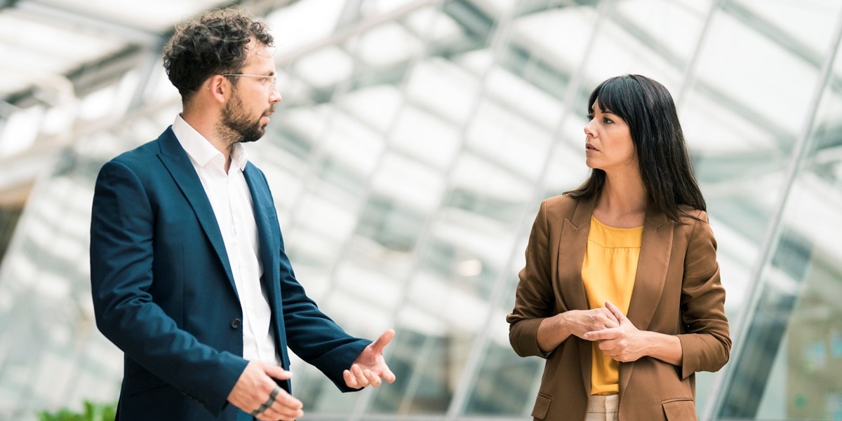 two professionals in office talking
