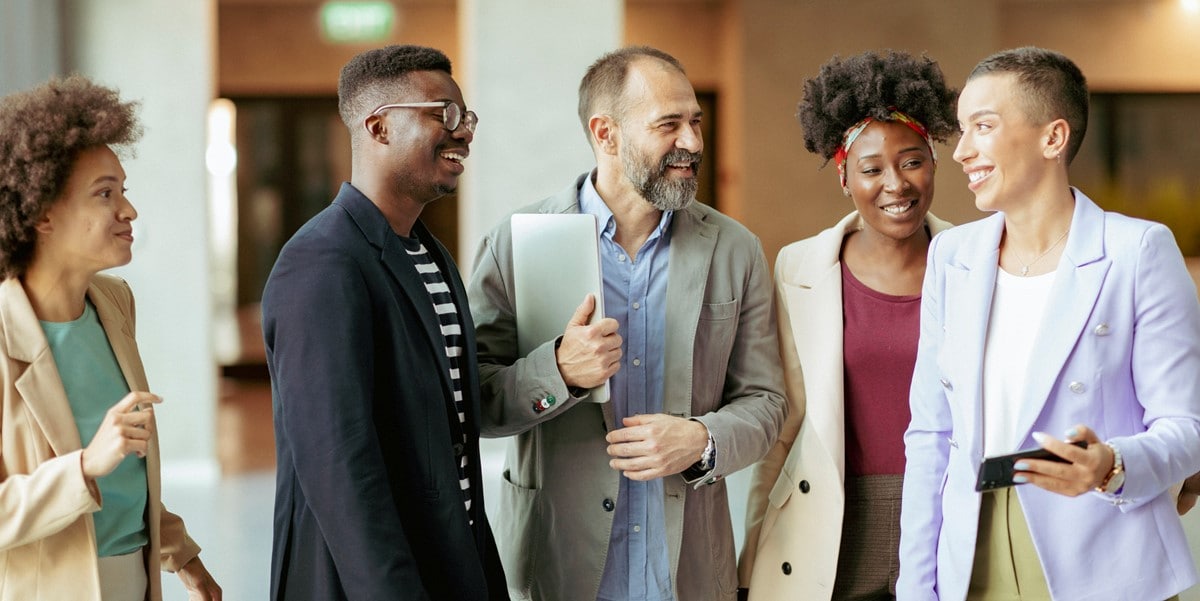 group of 5 people talking at office