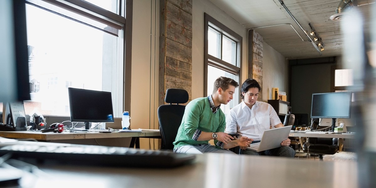 two men in an office reviewing a document