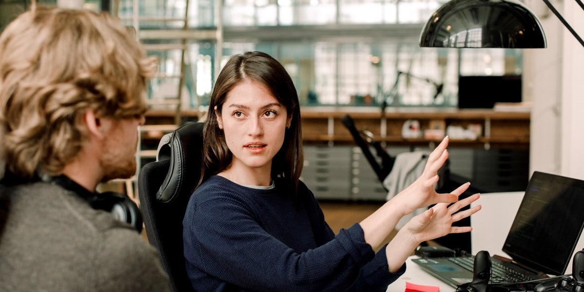 young woman explaining to colleague