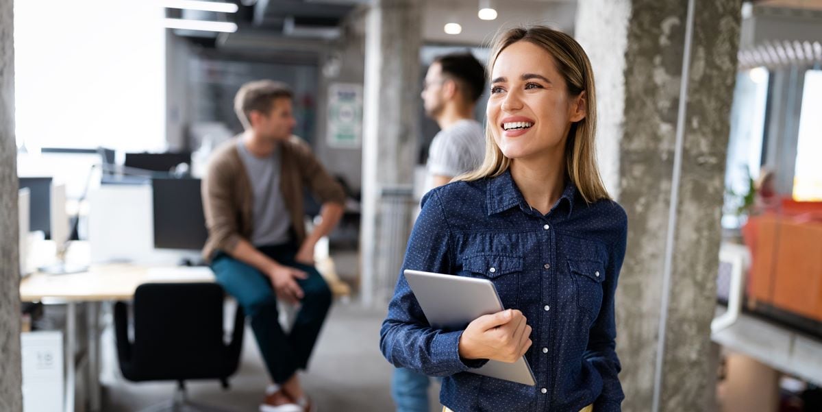 woman in office holding laptop