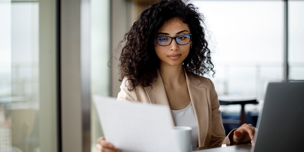 woman working at a desk looking at document