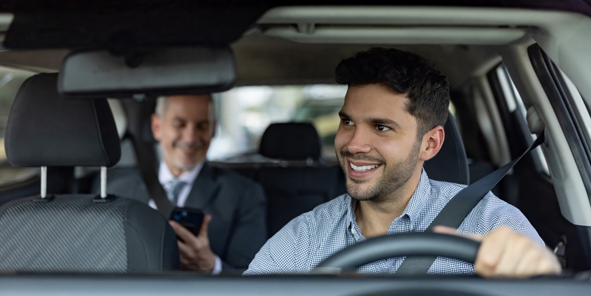 man driving with a passenger in the back, business traveler in rideshare