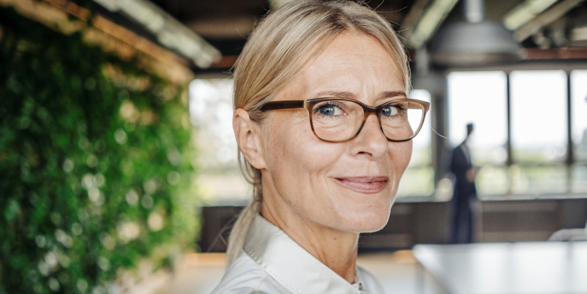 woman with glasses smiling, in the office