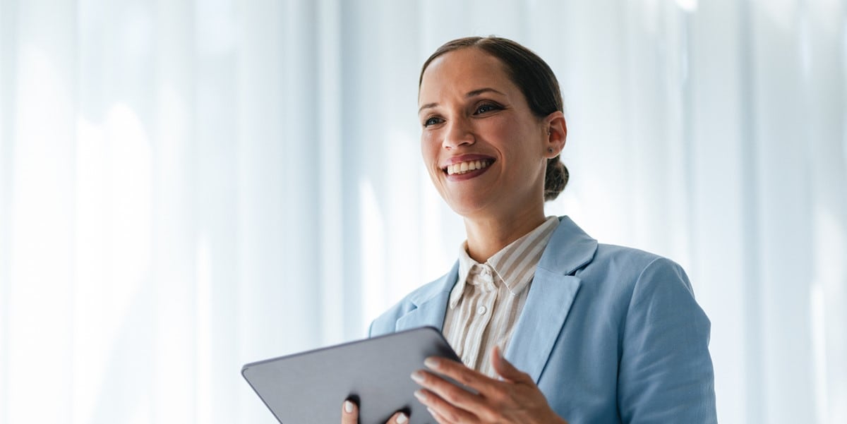 professional woman smiling, holding a tablet
