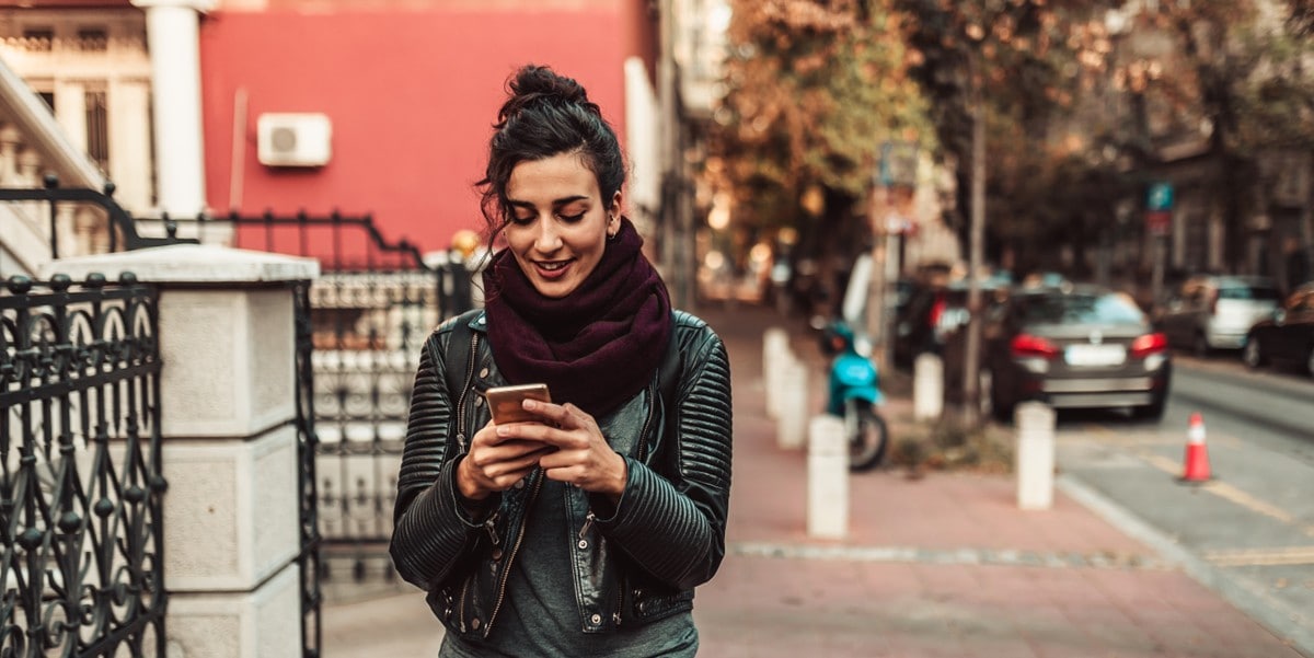 woman using cellphone, standing outside