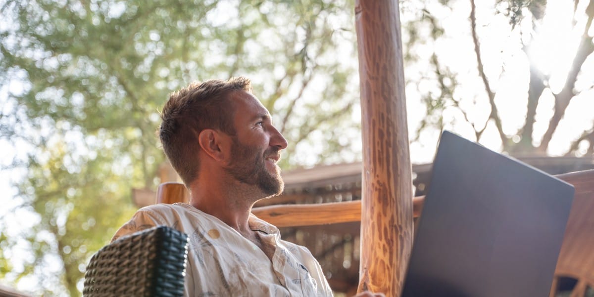 man working outdoors on laptop