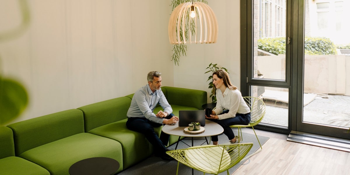 two professionals seated at a green couch