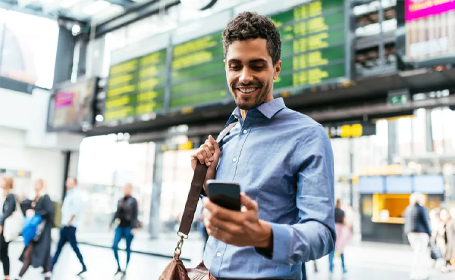 Man looking at phone in airport