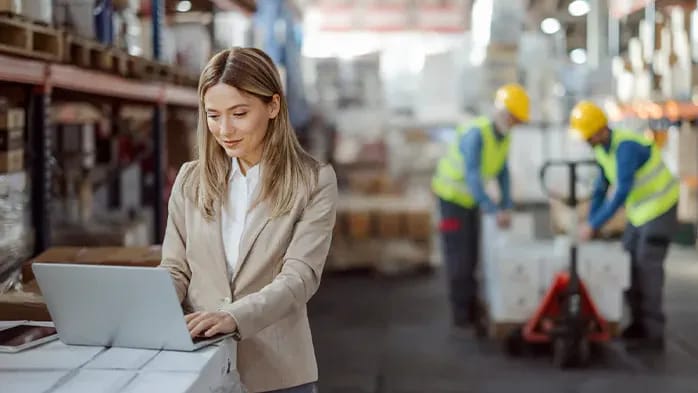 woman working on laptop in warehouse